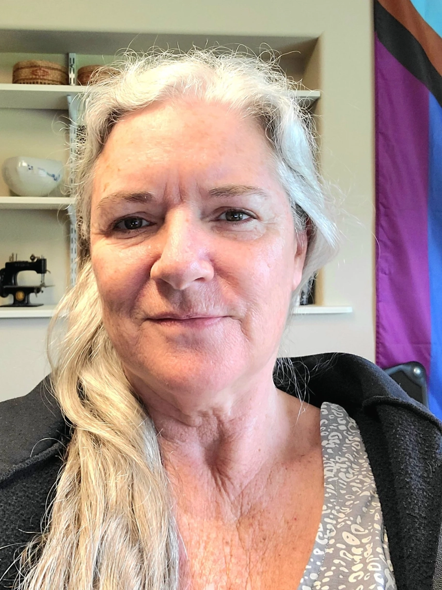 Older woman with long gray hair smiling.